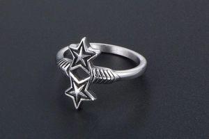 Macro shot of silver metal ring featuring connected twin stars with textured band detail