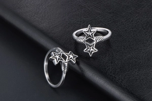Macro detail of vintage star and cross rings on textured black leather surface