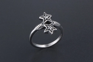 Macro shot of a silver star ring with diamond hollow design on a black background