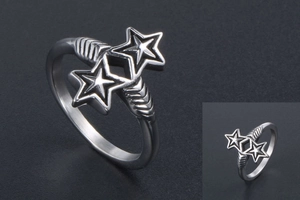 Macro detail of silver star ring featuring dual star motifs and vintage arrow textures