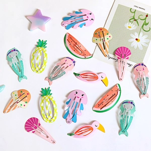 Detailed flat lay of colorful cartoon animal and fruit metal hair clips set on white