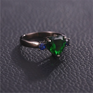Gothic black gold heart ring with green emerald and blue zircon accents on leather
