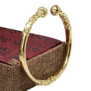 Detail of 18K gold-plated open bracelet with embossed spheres and woven texture