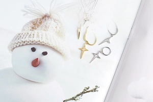 Close-up of minimalist S925 sterling silver star drop earrings on an open book page