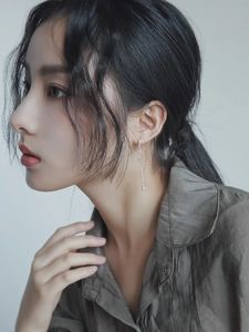 Silver long tassel chain earrings with square pendants worn on a model's ear