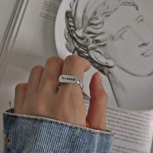 Close-up of a 925 sterling silver ring featuring an engraved breeze text design