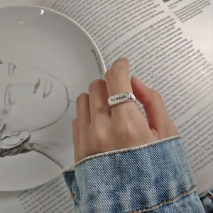 Detail of minimalist 925 silver ring featuring 'BREEZE' engraving on hand
