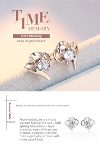 Macro detail of heart-shaped S925 silver stud earrings with sparkling round zircon stones