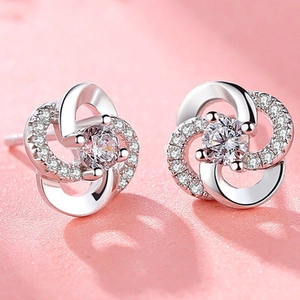Macro shot of silver clover stud earrings with large central crystal and pave zircons