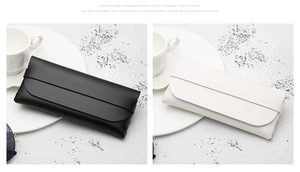 Detail of leather sunglasses cases in black and off-white with buckle closures