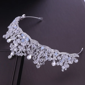 Elegant bridal tiara with silver rhinestones and light blue gems on dark background