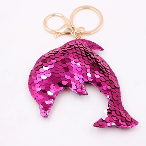 Close-up of pink sequined dolphin keychain with golden metal ring and lobster clasp