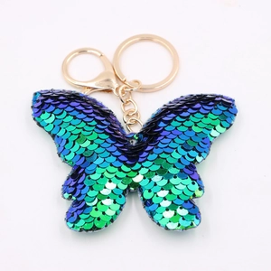 Blue-green gradient sequined butterfly keychain with golden metal ring on white background