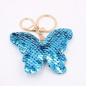 Close-up of blue sequin butterfly keychain with polished gold-tone metal hardware