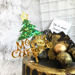 Detail of laser green acrylic Christmas tree cake topper with Merry Christmas gold text
