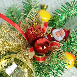 Christmas teardrop wreath with golden bells, red ribbon, and snowman on green pine needles