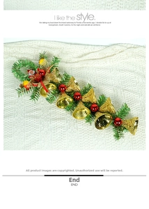 Detail of Christmas ornament with gold bells, green pine needles and a mini Santa doll