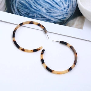 Detailed view of leopard print acrylic C-shaped hoop earrings with a smooth resin finish