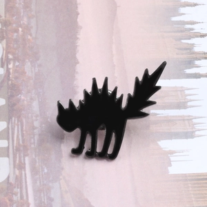 Macro detail of black cat enamel brooch with arching back in punk Halloween style