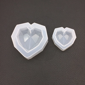 Vista macro di stampi in silicone a cuore geometrico con superfici sfaccettate per DIY