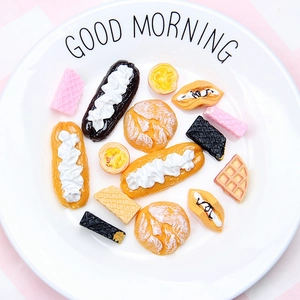 Close-up of assorted miniature resin desserts like croissants and waffles on a white plate