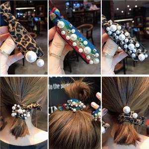 Detail shot of leopard print and rainbow hair ties with pearl and silver bead accents