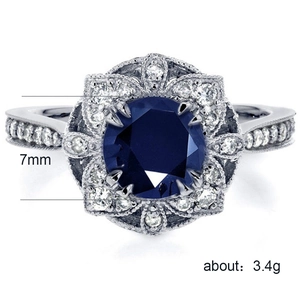 Macro de bague en argent avec zircon bleu 7mm et détails floraux ajourés élégants