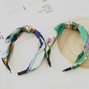Detailed top view of two satin knotted headbands featuring elegant chain and geometric prints