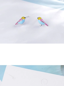 Detail of bird-shaped enamel stud earrings with blue body and pink wings decoration