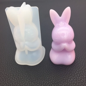 DIY silicone mold with purple rabbit resin craft on a black textured background