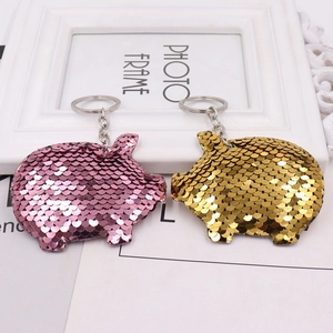 Pink and gold sequin pig keychains displayed against a white frame for bags or cars