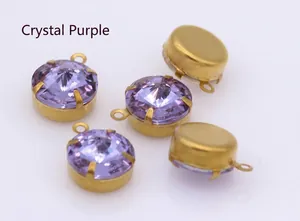 Macro detail of crystal purple faceted round glass pendants with gold claw setting