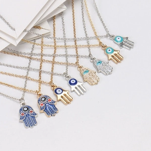 Detailed fan-shaped layout of Hamsa Hand necklaces in gold and silver with blue devil eyes