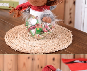 Close-up of reindeer plush toy top and clear plastic Christmas candy jar filled with sweets