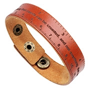 Detail of brown leather bracelet featuring vintage scale markings and engraved quote
