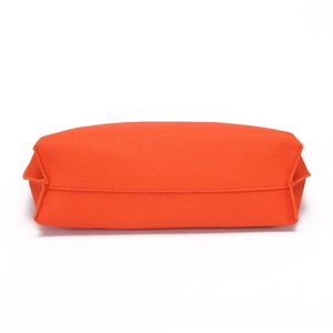 Detailed bottom view of orange pebble leather tote bag showing high-quality stitching