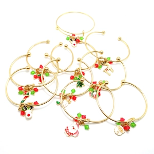 Detail view of festive gold Christmas charm bracelets with colorful enamel pendants