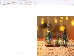 Detailed view of three mini artificial Christmas trees with LED lights and wooden bases