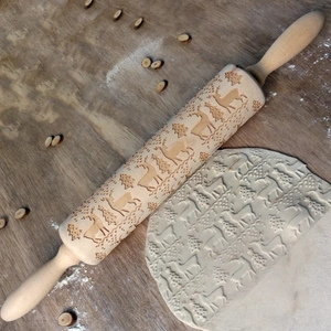Detail of laser engraved wooden rolling pin with Christmas reindeer and tree patterns