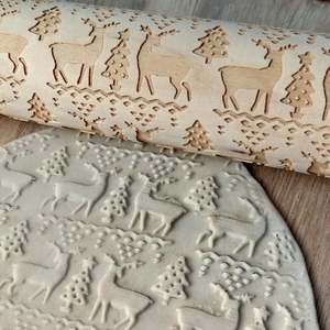 Close-up of wooden rolling pin with engraved Christmas deer and trees patterns