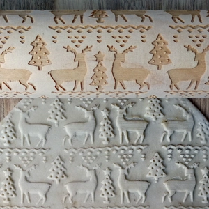 Detail of wooden rolling pin with laser engraved Christmas deer and tree patterns