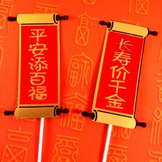 Detail of red and gold scrolls with Chinese calligraphy on sticks for cake decoration