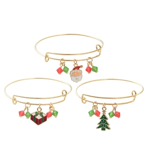 Detailed shot of gold-plated Christmas bangles with Santa and tree enamel charms