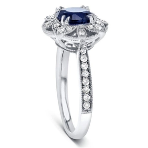 Détail de la bague fleur ajourée avec zircon bleu ovale et sertissage latéral en pavé