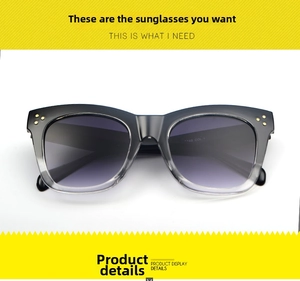 Detail of square oversized sunglasses with grey gradient lenses and gold rivets