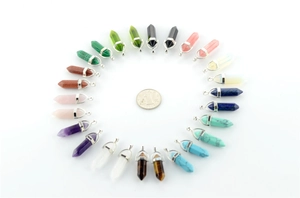 Macro view of 24 colorful hexagonal quartz point pendants with a coin for scale