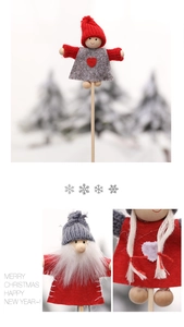 Macro shot of handmade Christmas wooden picks with knitted red hats and Santa Claus dolls