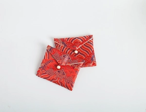 Detail of red brocade jewelry pouches with golden embroidery and pearl closures