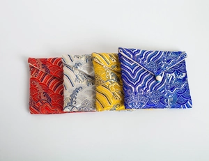 Detail of brocade jewelry pouches in red, silver, yellow, and blue with pearl buttons