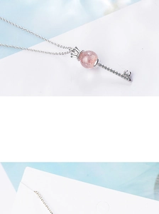 Detailed view of pink crystal crown key pendant necklace with sparkling micro-diamonds